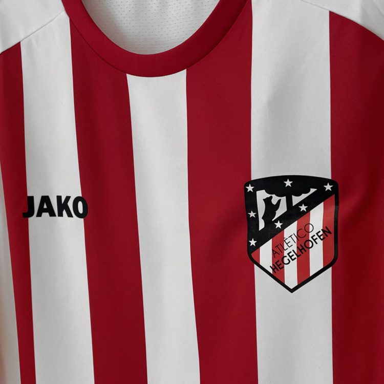 schwarzes Atletico Logo auf den rot weißen Trikots