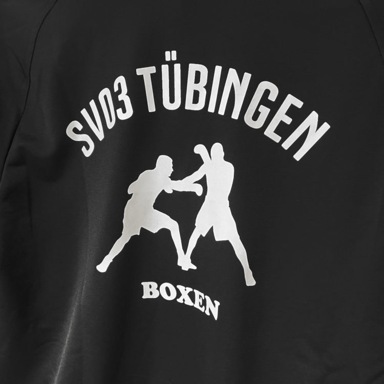 Das Boxen Logo als Bedruckung in weiß auf den schwarzen adidas Jacken