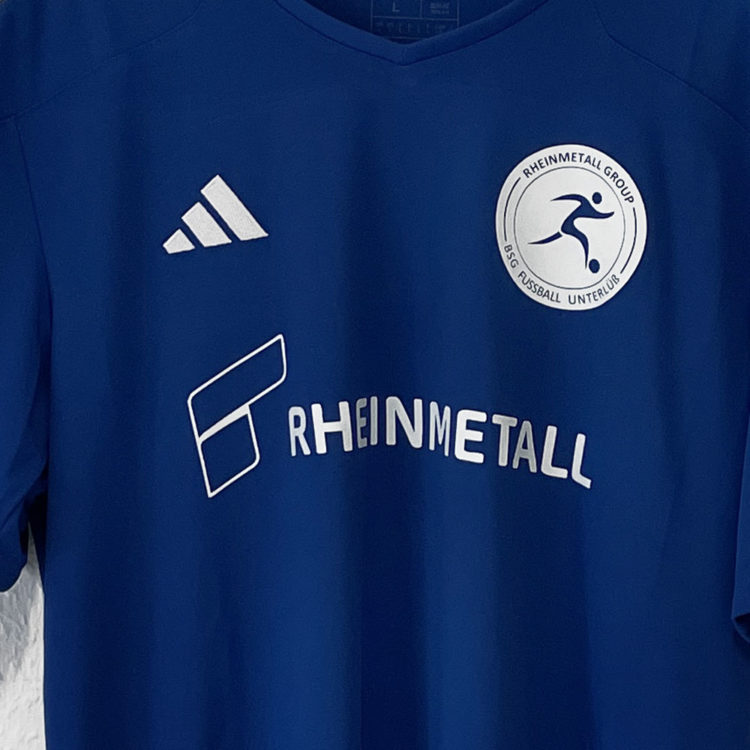 weißes Rheinmetall Logo auf den blauen Trikots von adidas