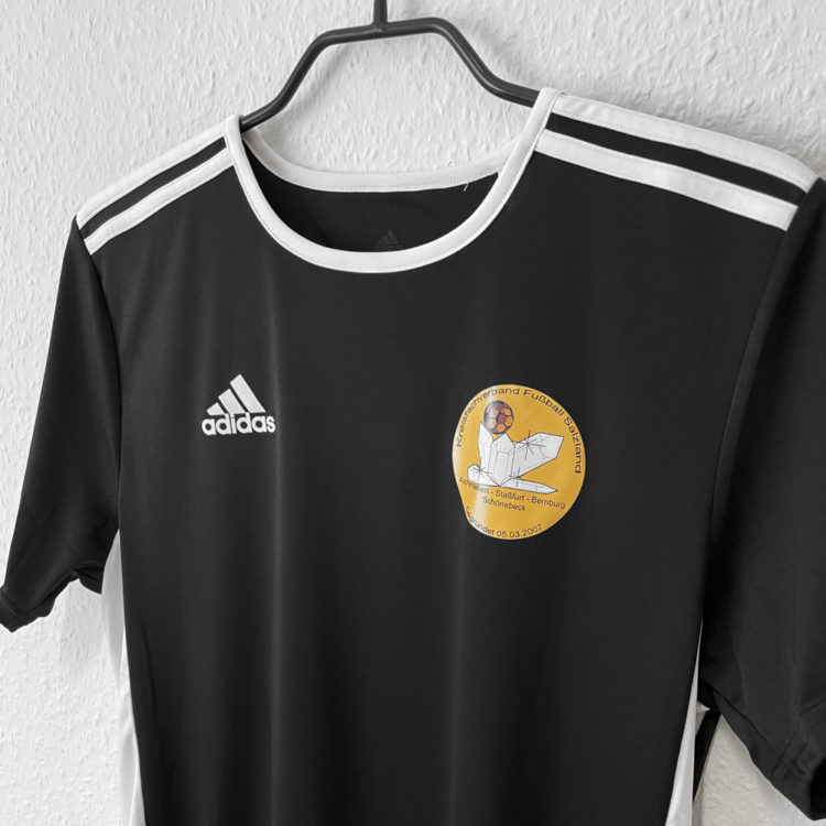 Das adidas Schiedsrichter Shirt mit dem Wappen als Druck auf der Brust
