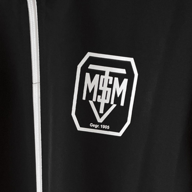 Das weiße TSVM-Vereinswappen auf den schwarzen adidas Jacken