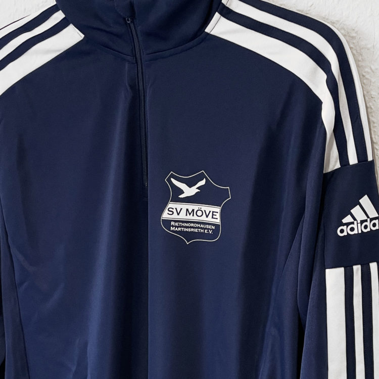 das weiße Vereinslogo auf dem marine blauen adidas Training Top