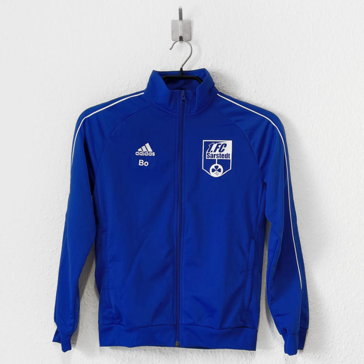 Bei diesen adidas Kinder Trainingsjacken ist das Vereinswappen auf die Brust bedruckt.