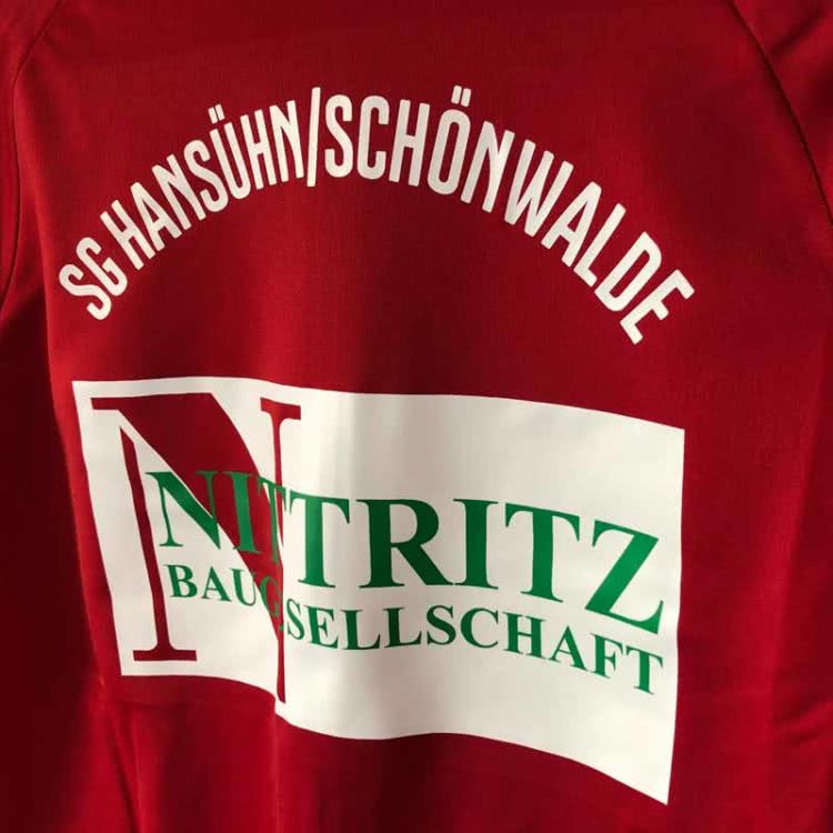 die adidas Polyesterjacke mit Vereinsnamen und Werbung der SG Hansühn Schönwalde