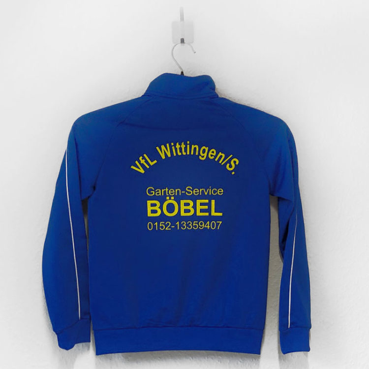 Die adidas Trainingsjacke mit Vereinsname und Werbung (als Druck) auf dem Rücken