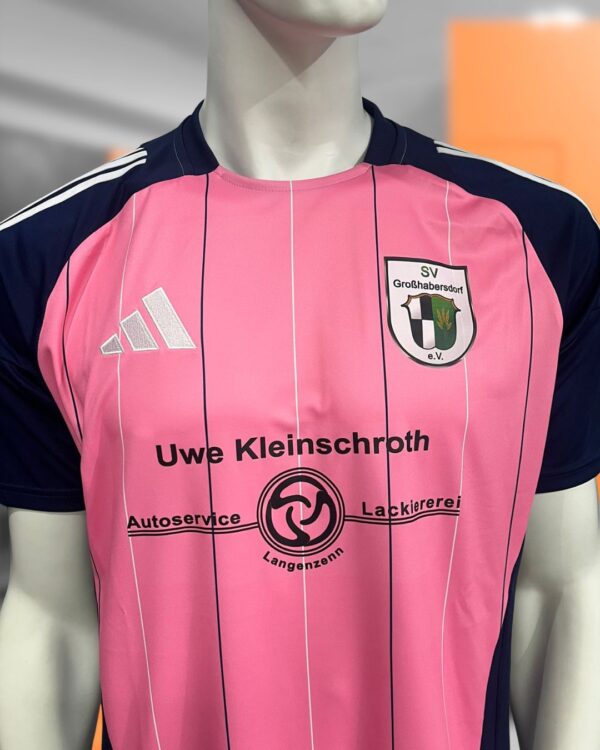 Die pinken adidas Trikots mit Sponsorenlogo und Vereinswappen