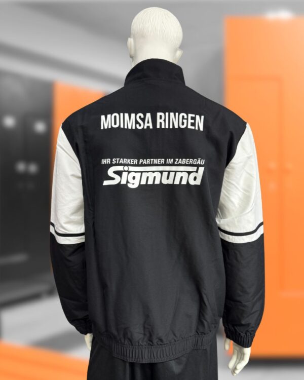 die schwarze adidas Teamjacke mit Vereinsnamen und Sponsorenwerbung